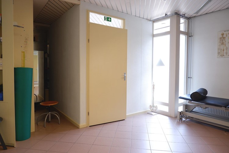 Vanuit de wachtruimte toegang tot de behandelkamer met een aparte inloop opbergruimte.