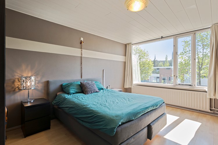 Slaapkamer gelegen aan de achterzijde, met een laminaatvloer, structuurverf wanden en een MDF plafond. Daglicht via een hardhouten raamkozijn met  dubbele beglazing. 