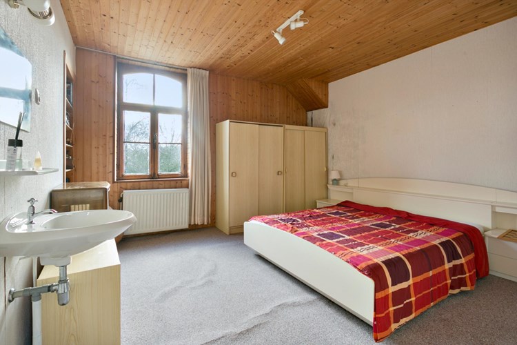 Slaapkamer (afmeting ca. 4,00 m. x 4,00 m.) gelegen aan de voorzijde, met vloerbedekking, behangen wanden en een schroten plafond. Met een vaste wastafel en een radiator. 