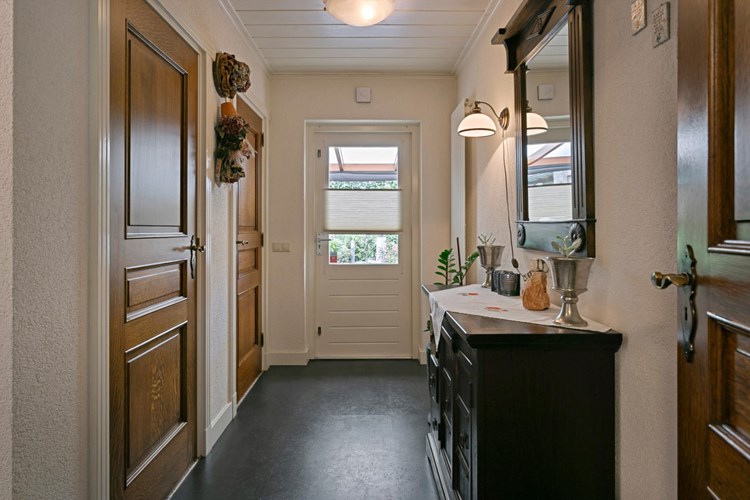 Dit portaal is bereikbaar vanuit de keuken met toegang tot het toilet, doucheruimte, tuinkamer/overdekt terras en een toegangsdeur naar de carport. 
Portaal met een antraciet PVC vloer met vloerverwarming, spachtelputz wanden en een MDF plafond. 