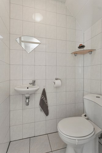 Het toilet is volledig licht betegeld met een spuitwerk plafond. Voorzien van een duoblok, een fonteintje en mechanische ventilatie. 