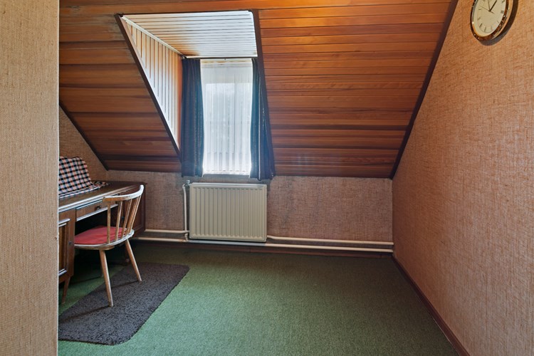 Slaapkamer, gelegen aan de voorzijde, met vloerbedekking, behangen wanden en een schroten plafond. Daglicht via een dakkapel met een hardhouten raamkozijn met enkele beglazing. 