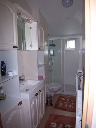 De prachtige badkamer heeft een ruime inloopdouche, badmeubel met wastafel en zwevend toilet.