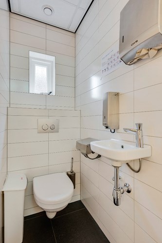 Volledig betegeld toilet met een wandcloset met opzetplateau en een fonteintje. Zowel mechanische- als natuurlijke ventilatie aanwezig. 