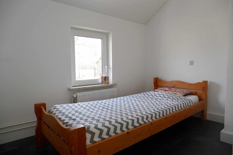Slaapkamer gelegen aan de voorzijde, met een laminaatvloer, stucwerk wanden en een kunststof schroten plafond. Daglicht via een kunststof raamkozijn (draai-/kiep) met dubbele beglazing. 
