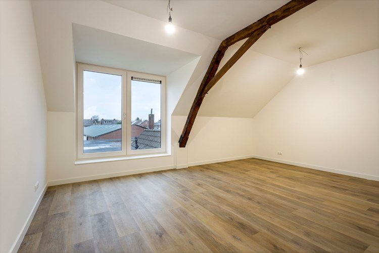 Op de gang toegang tot de royale woonkamer/keuken, ca. 31 m2.. 
Met een PVC vloer met vloerverwarming, stucwerk wanden en een stucwerk plafond. In de leefruimte is het originele houten kapspant zichtbaar.

