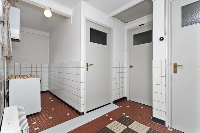 Het portaal in de bijkeuken verschaft u toegang tot de achtertuin, separate ruime toiletruimte met fonteintje, badkamer en een inbouwkast. Ook vindt u hier een luik naar de bergzolder.